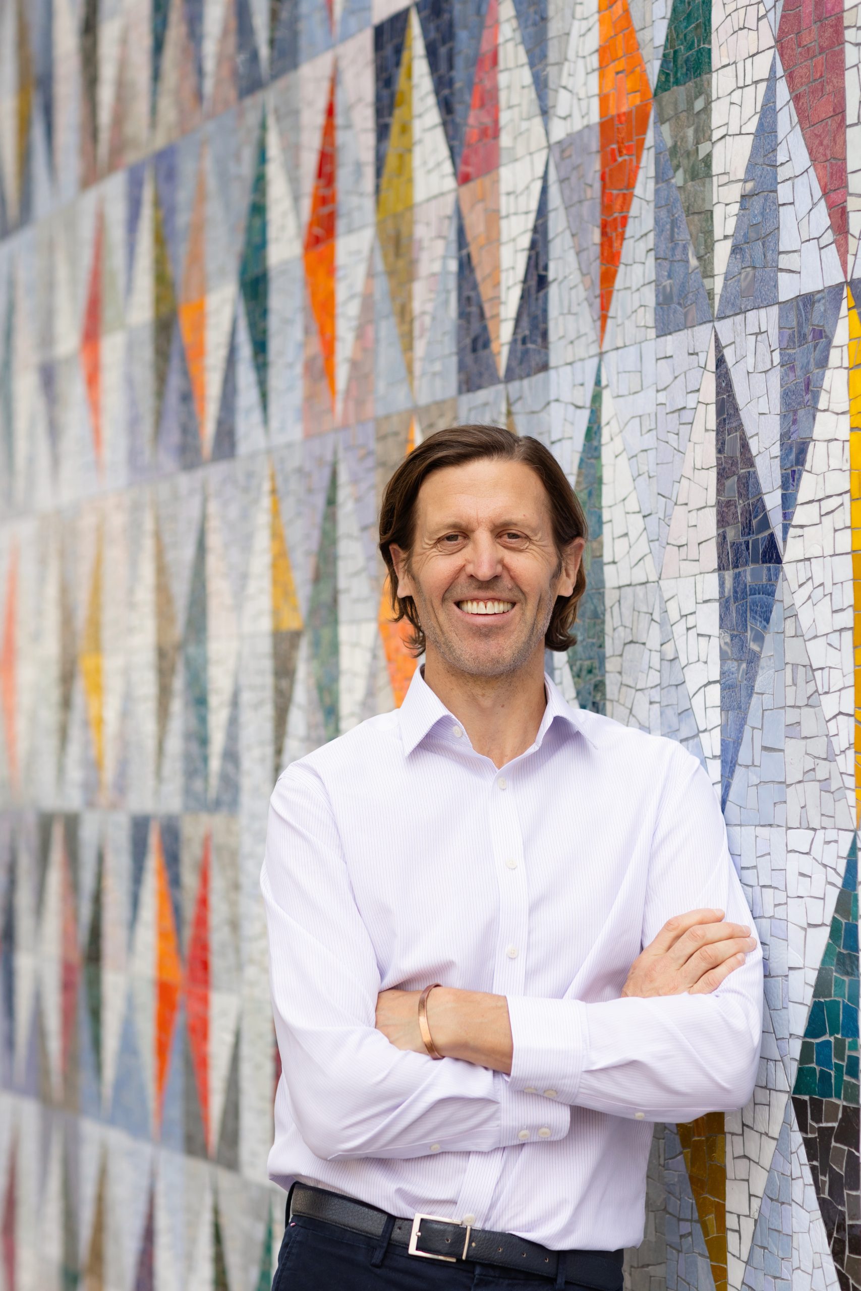 Picture of a business coach standing against a colourful wall in London during a personal branding shoot.